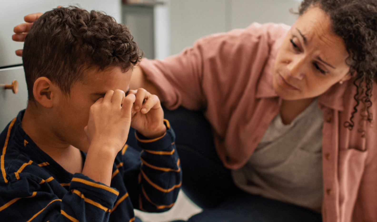A parent gently comforting their upset kid